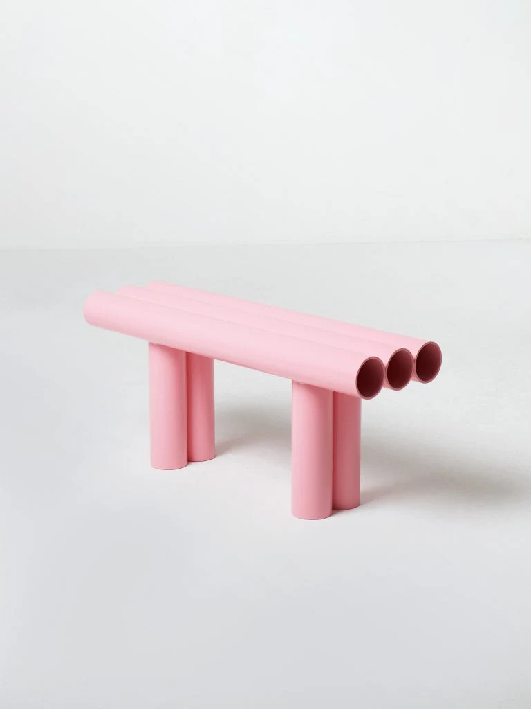 Banc sculptural rose pastel d'Axel Chay photographié sur fond de studio épuré.