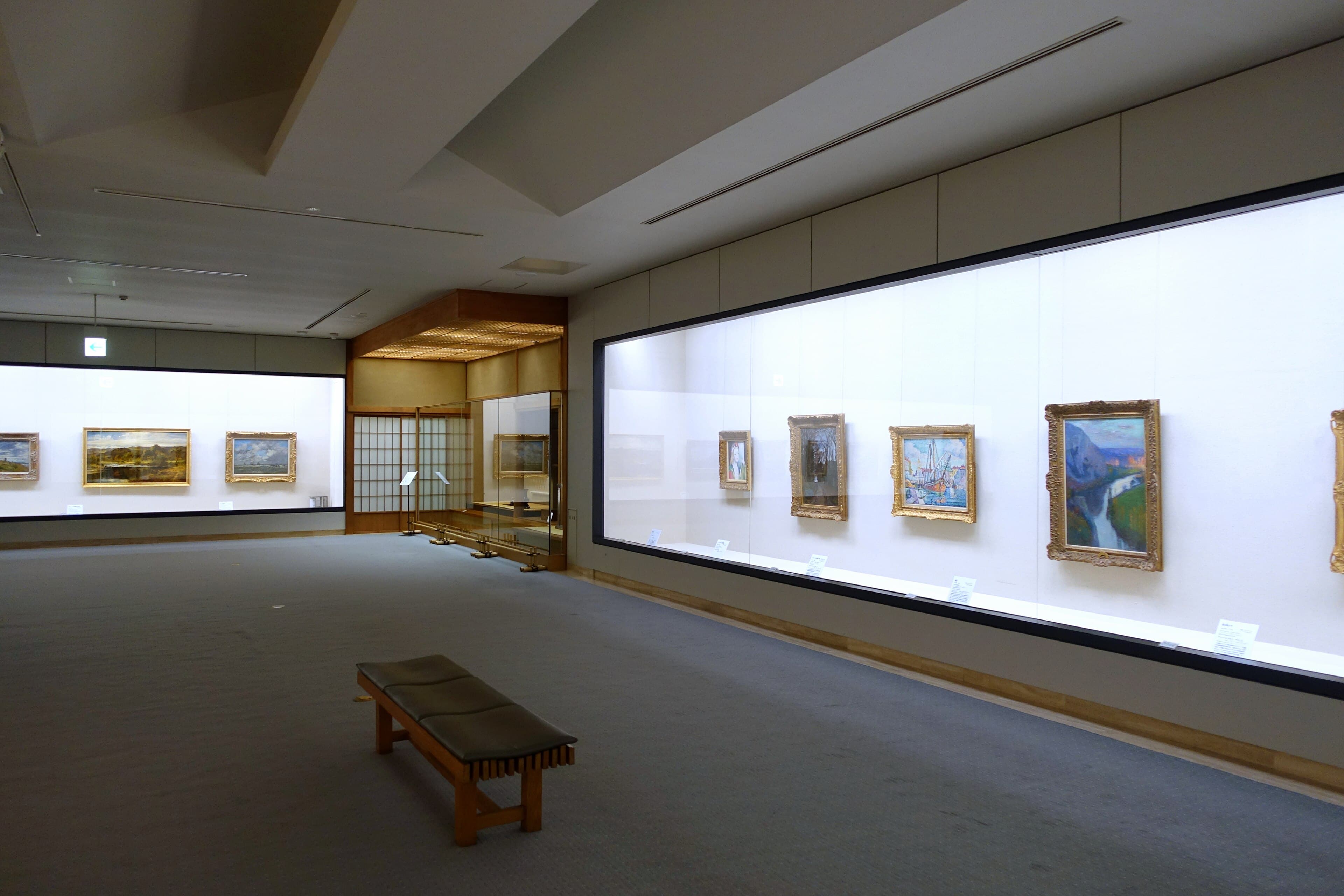 Quiet gallery interior with framed works and dramatic architectural lines.